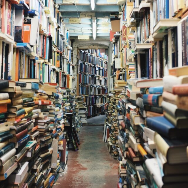 Pathway in the middle of piled books. Original public domain image from Wikimedia Commons